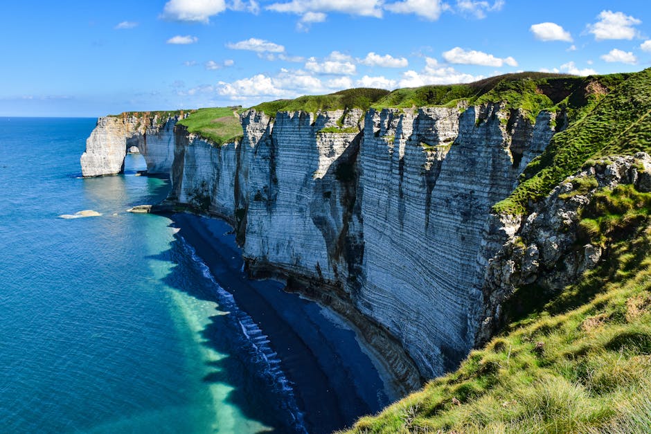 Explore the stunning cliffs of Étretat in Normandy with sweeping views over the sea and sky.